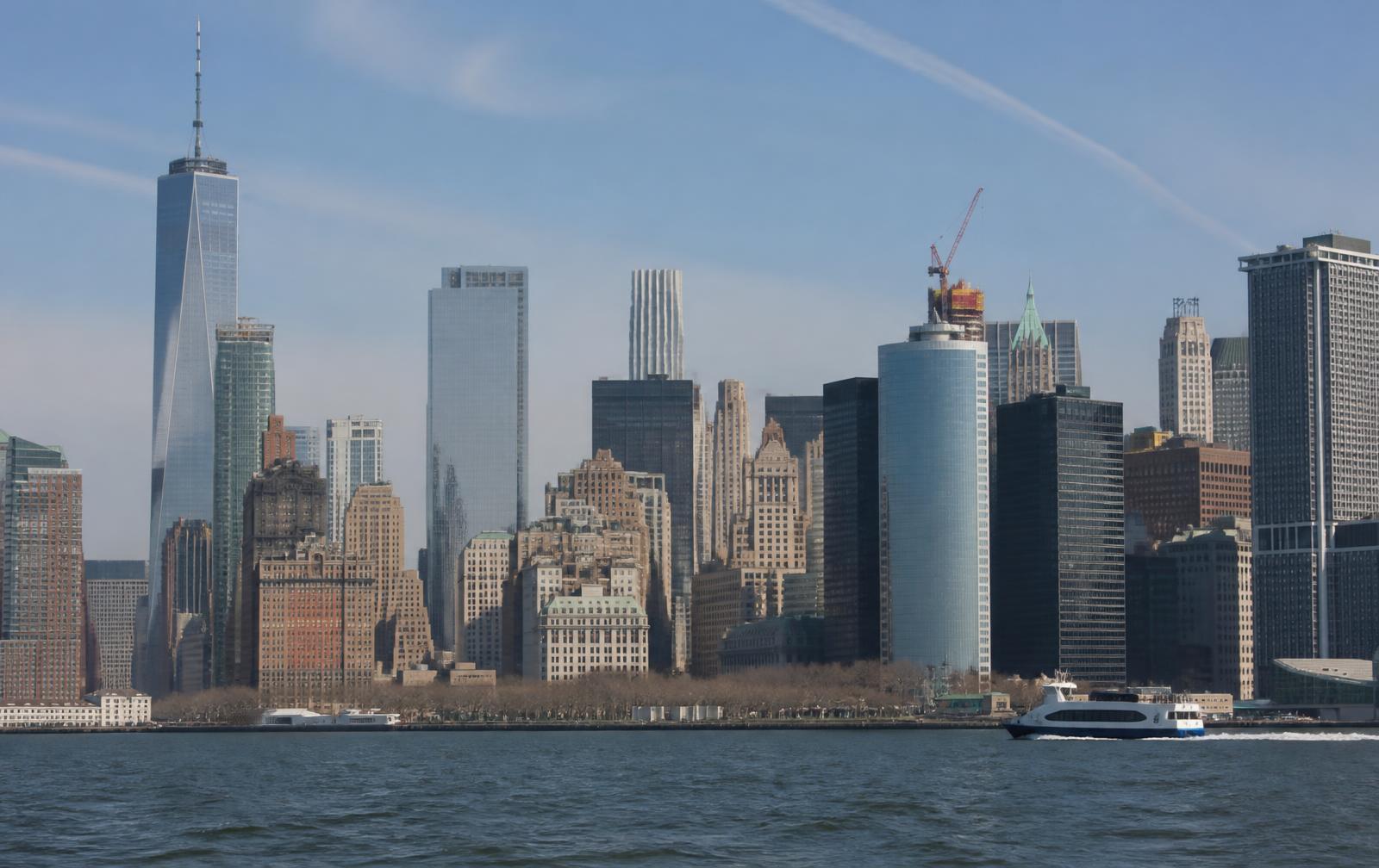 Sunlit Lower Manhattan skyline seen from the harbor